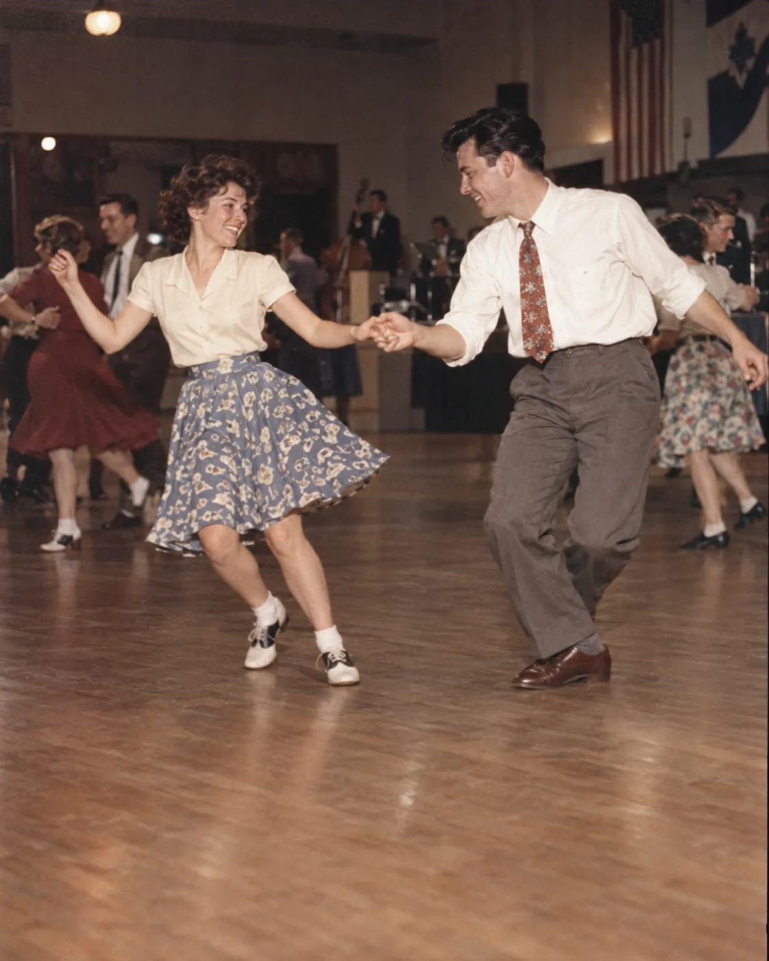Una pareja baila swing en un salón de luz cálida